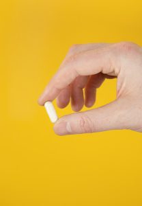 person holding white cigarette stick - flea and tick prevention